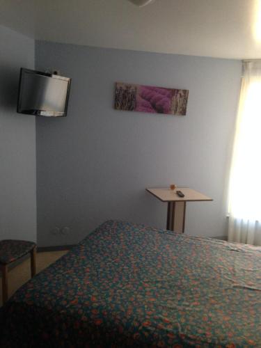 1 dormitorio con 1 cama y TV en la pared en Le Boudes la vigne, en Boudes