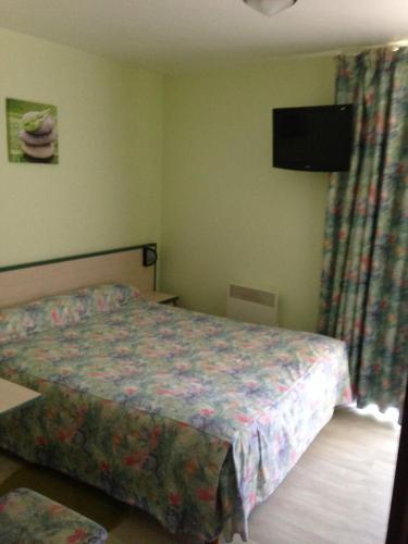 une chambre avec un lit et une télévision à écran plat dans l'établissement Le Boudes la vigne, à Boudes