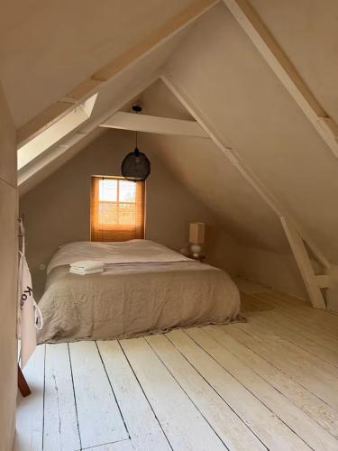 a bedroom with a large bed in a attic at Maison 1882 in Hauwert