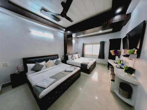 a room with a bed and a couch and a table at Evesta Micasa in Haridwār