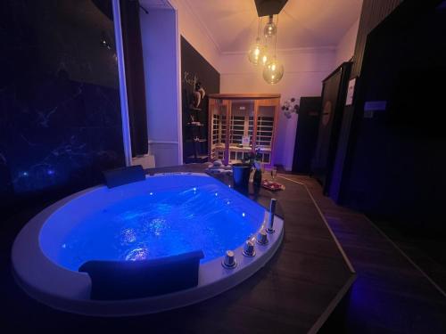 a large blue tub in a dark room at SUITE KASSIOPEE, romantisme, balnéo, sauna in Quimperlé