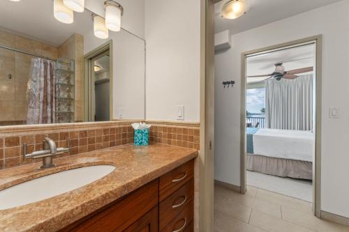 a bathroom with a sink and a mirror and a bed at Mana Kai 611C in Wailea