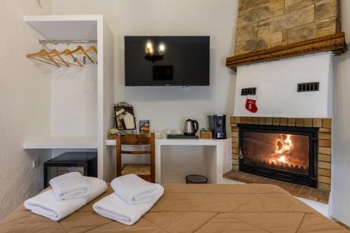 a bedroom with a fireplace and a bed with towels at Rigas Hotel Arachova in Arachova