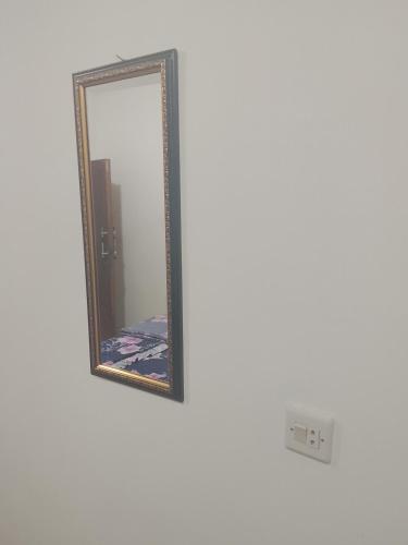 a mirror with a gold frame on a white wall at Widodaren Homestay twin bed in Ngadisari