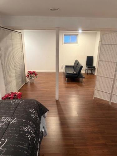 a room with a bed and a couch and a chair at Cozy Studio in Elmont