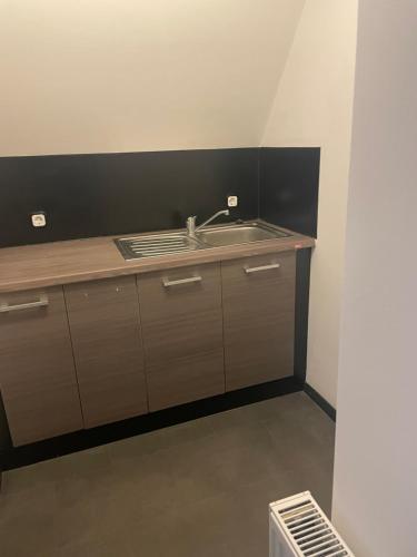 a kitchen with a sink and a black wall at Aydogan Vermietung in Stade