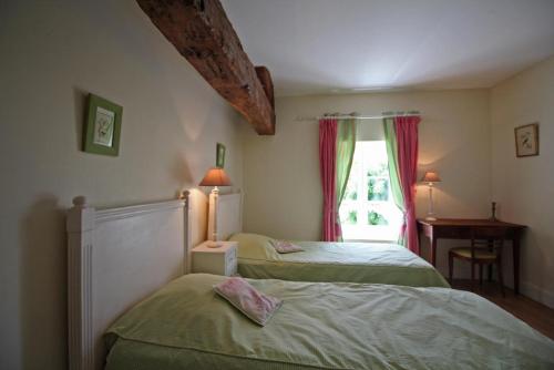 a bedroom with two beds and a window at La métairie in Isle