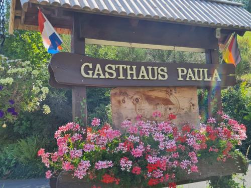 a sign for a restaurant with a bunch of flowers at Gasthaus Paula in Üdersdorf
