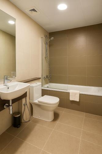 a bathroom with a toilet and a sink and a shower at Prime Apartments Near WTC and Sheikh Zayed RD in Dubai