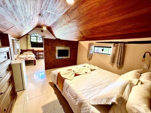 a bedroom with two beds and a wooden ceiling at Castelar da Alvorada in Vale do Capao