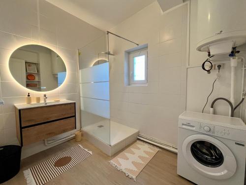 a bathroom with a washing machine and a sink at Chez MARIE in Valence