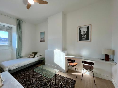 a bedroom with a bed and a desk and two chairs at Chez MARIE in Valence