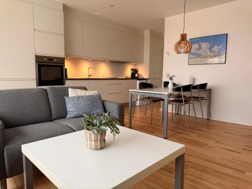 a living room with a couch and a table at Plesners Havnelejligheder in Skagen