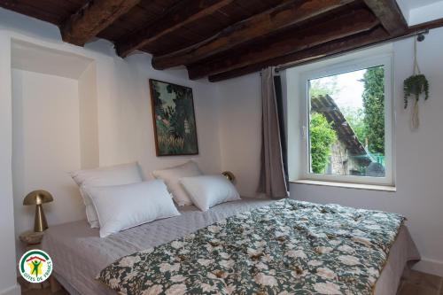 a bedroom with a bed with a window at Gîte la Planta de Cossey 2 in Claix
