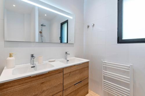 a bathroom with a sink and a mirror at Villa U Capu - Piscine Privée in Lecci