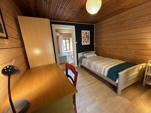 a bedroom with a bed and a desk in a room at Le chat qui pêche in Rilhac-Rancon