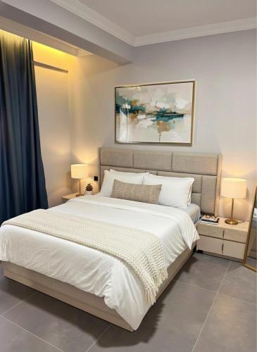 a bedroom with a large white bed and two lamps at Arsuz Suit in Hatay