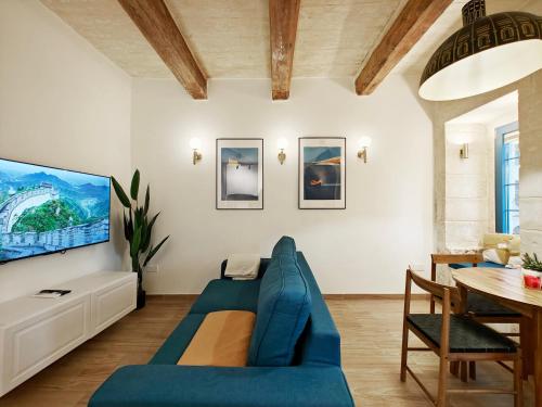 a living room with a blue couch and a table at Valletta Dome Apartment in Valletta