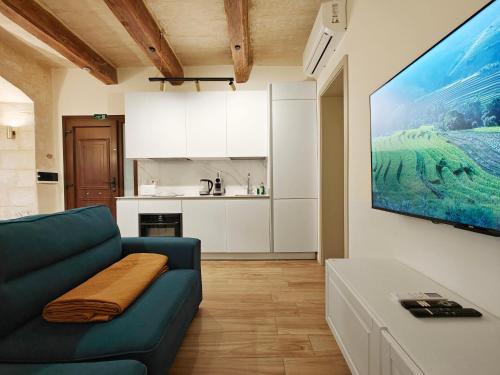 a living room with a blue couch and a kitchen at Valletta Dome Apartment in Valletta