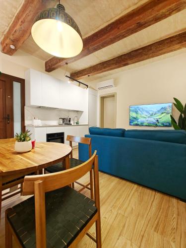 a living room with a blue couch and a table at Valletta Dome Apartment in Valletta