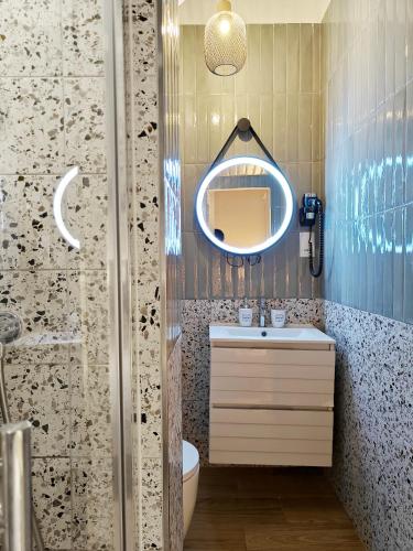 a bathroom with a sink and a mirror at Valletta Dome Apartment in Valletta