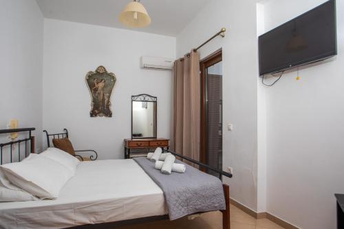 a bedroom with a bed and a flat screen tv at Christine Beachside Villa Pefkos in Pefki