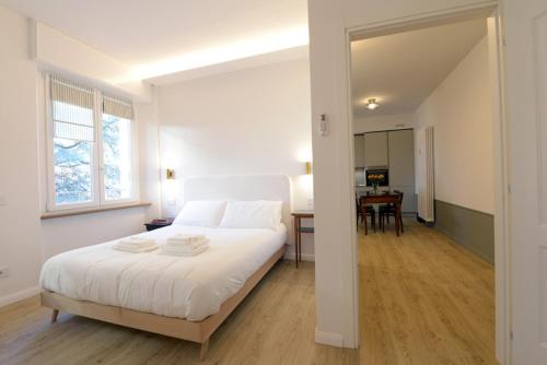 a bedroom with a large white bed and a table at LA FORESTERIA Case a Varese in Varese