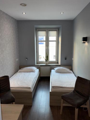En eller flere senge i et værelse på Hostel Promenada