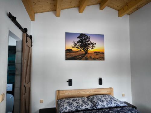 a bedroom with a bed and a tree on the wall at Resort Radslavice in Přerov