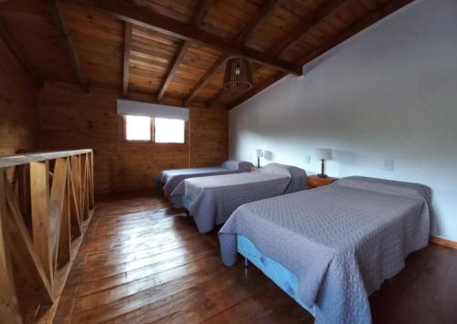 a room with three beds in a room at Complejo Maylen Meliquina in Lago Meliquina