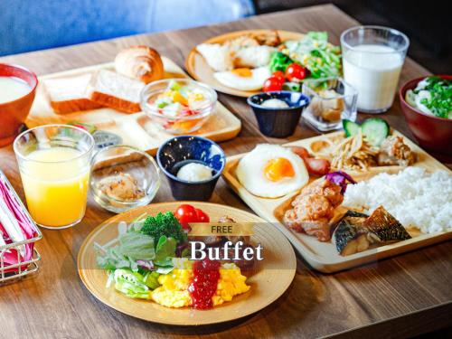 a wooden table topped with plates of food and drinks at Hotel BaliAn Resort Kawasaki in Kawasaki