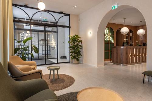a lobby with chairs and tables in a building at Konventa Sēta Hotel - Keystone Collection in Riga