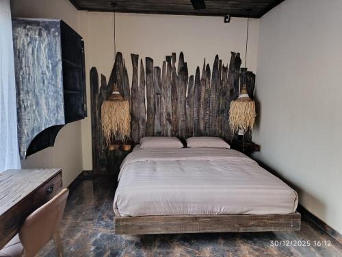 a bedroom with a bed with a wooden headboard at Jagad Villa with 3 Bedroom in Ungasan