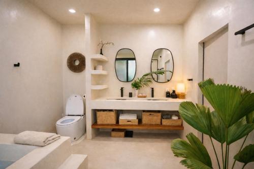 a bathroom with a toilet and a sink and a mirror at Villa Nomada Exclusive Modern Seaview Spa and Wellness Villa with Daily Housekeeping 5 Bedrooms Sauna Ice Bath and 20 Meter Private Saltwater Pool in Ban Bang Po