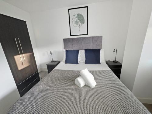 a bedroom with a bed with two pillows on it at Regent Circus Apartments in Swindon