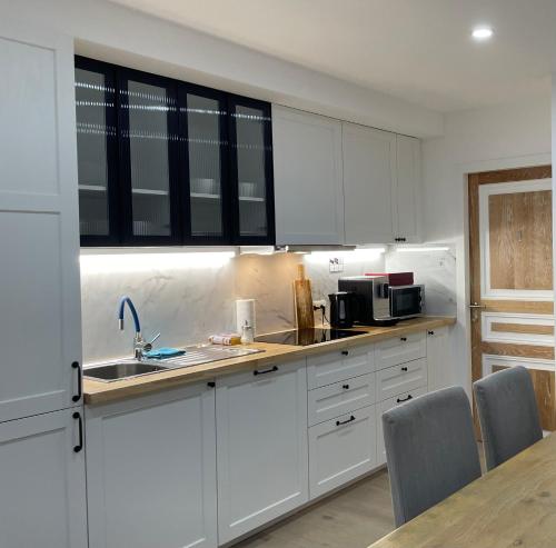 a kitchen with white cabinets and a sink at Rooms Brussels Airport- 'The Good Place' in Zaventem