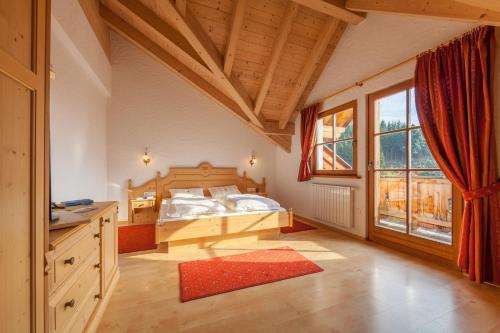 ein Schlafzimmer mit einem Bett und einem großen Fenster in der Unterkunft Hotel Tolderhof in Innichen