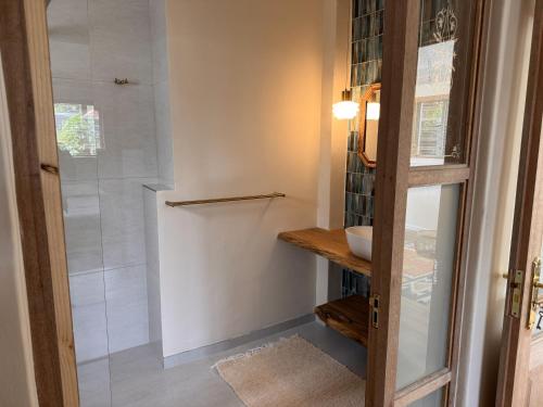 a bathroom with a shower and a sink at Mimosa Cottage in Cape Town