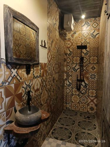 a bathroom with a sink and a tiled wall at Jagad Villa with 3 Bedroom in Ungasan