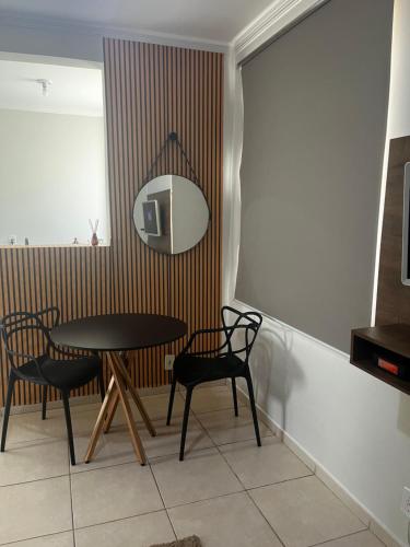 a dining room with a table and chairs and a mirror at Apto 2 quartos, Wi-Fi rápido, Self check in in Uberlândia
