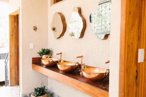 a bathroom with three copper bowls on a counter at Pousada Real in Caldas Novas