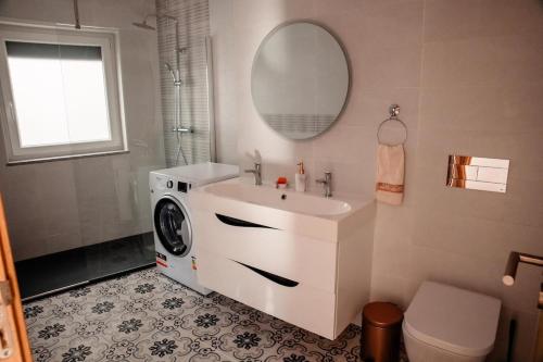 a bathroom with a sink and a washing machine at Casa da avo Rita in Pêro Viseu