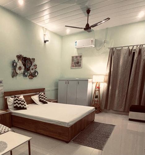 a bedroom with a bed and a ceiling fan at Aranyaa Cottage Homestay Vrindavan in Jait