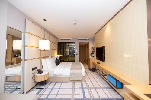 a hotel room with a bed and a tv at 7Crown Tahliah Hotel in Riyadh