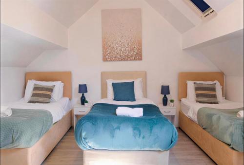 two twin beds in a room with two lamps at Walsgrave Road 3BR Multi-Floor Apartment Unit - Free Parking & WiFi in Wyken