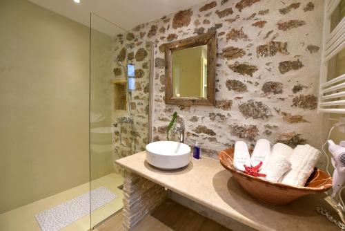 a bathroom with a sink and a glass shower at Sterna Apartment in Hydra