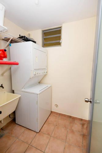 a kitchen with a white refrigerator and a tile floor at Beach condo with 3 bedrooms and ocean views in Rio Grande
