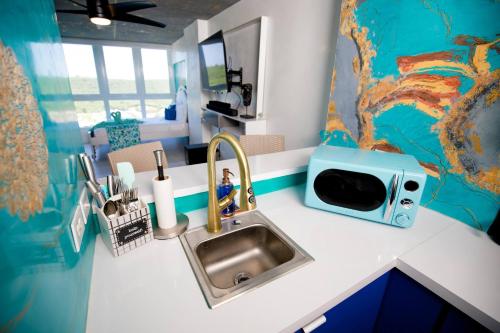 a kitchen counter with a sink and a microwave at Ocean view condo with pool & fits 3 in Fajardo