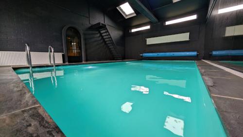 a swimming pool with blue water in a building at Gastenverblijf Zomerdijk in Meppel