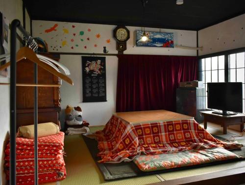 a bedroom with a bed and a television in it at Zaō Hütte 一棟貸し in Zao